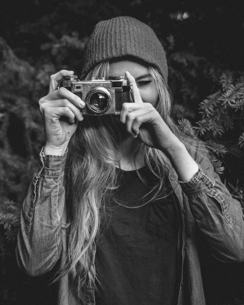 Jeune femme avec un appareil photo, style décontracté, en extérieur.